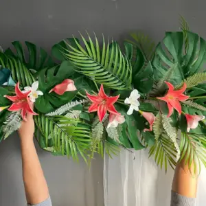 ft beach wedding archway decorated with tropical teal and coral flowers, palm and monstera leaves, and a corner swag garland, creating a vibrant coastal wedding backdrop