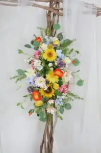 Wildflower wedding tie-back featuring sunflowers, daisies, dahlias, and ranunculus, designed for a boho spring wedding backdrop, arbour, or gazebo decoration